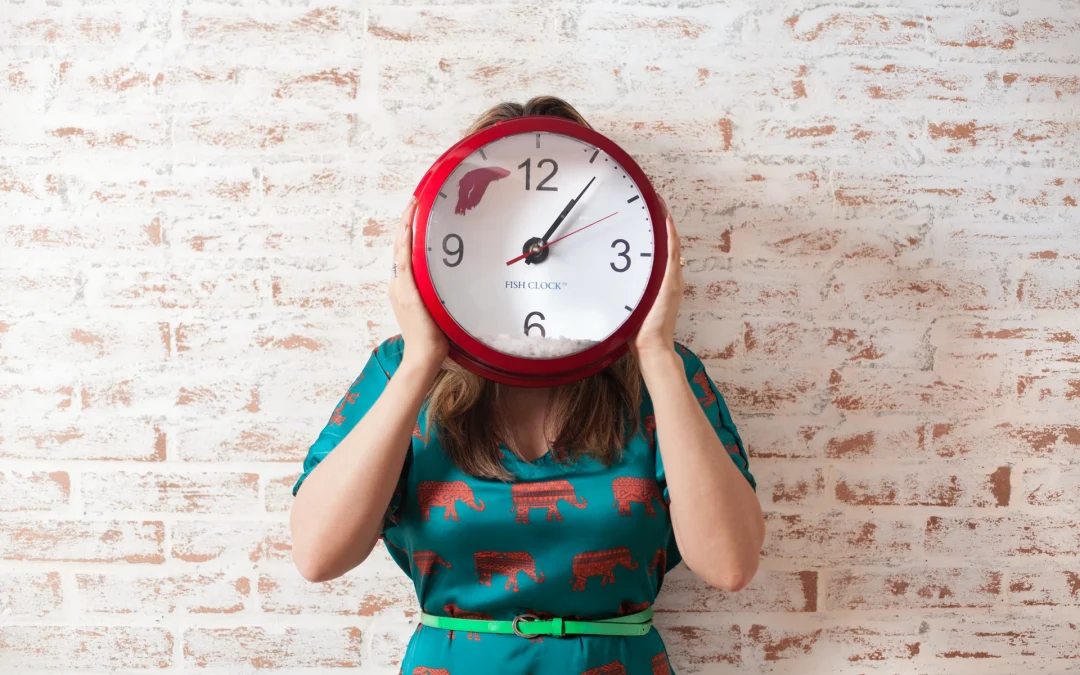 Woman holding clock to cover her face